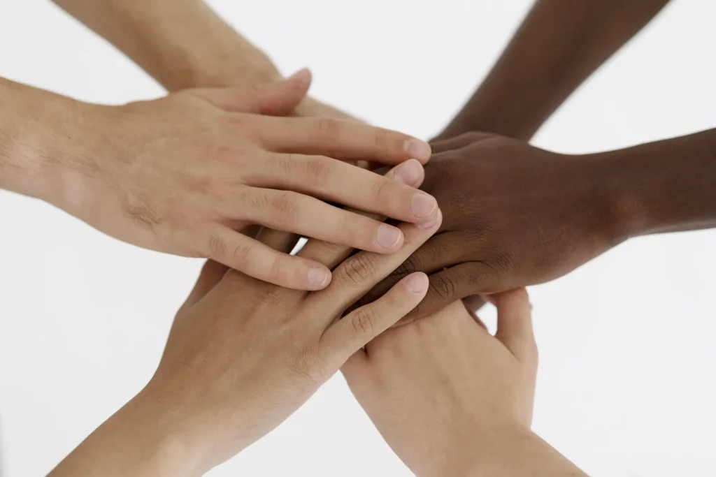 Close-up-people-connecting-through-hands Jura Migrants